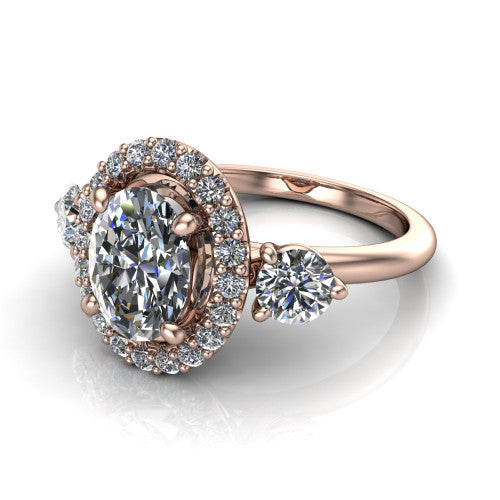 Carol oval three stone halo engagement ring in 14K Rose Gold, three-quarter perspective showing the oval center in a squared pav&eacute; halo flanked by two round side stones above a plain band