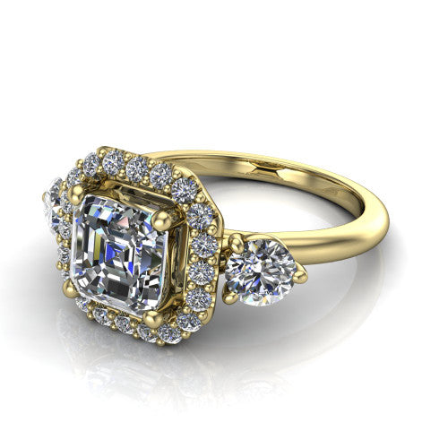 Carol square emerald three stone halo engagement ring in 14K Yellow Gold, three-quarter perspective showing the square emerald center in a squared pav&eacute; halo flanked by two round side stones above a plain band