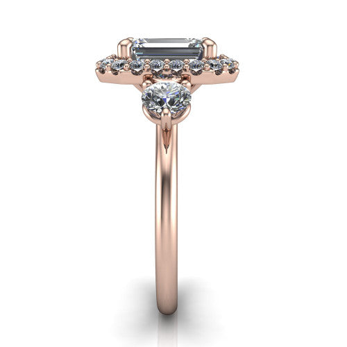 Carol emerald three stone halo engagement ring in 18K Rose Gold, side profile showing the plain polished band and the three-stone halo head in profile