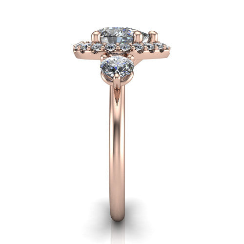 Carol pear three stone halo engagement ring in 18K Rose Gold, side profile showing the plain polished band and the three-stone halo head in profile