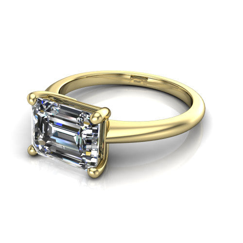 Avery emerald classic solitaire engagement ring in 18K Yellow Gold, three-quarter perspective showing the emerald center on claw prongs above a plain polished band