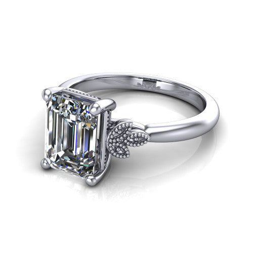 Athena emerald vintage solitaire engagement ring in 14K White Gold, three-quarter perspective showing the emerald center on claw prongs above a plain band with fleur-de-lis filigree accents