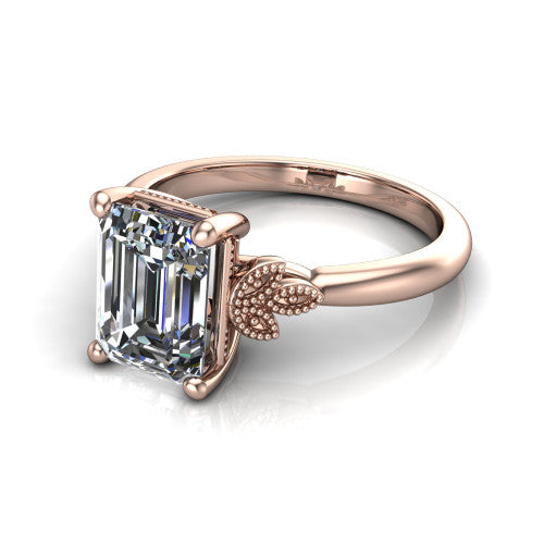 Athena emerald vintage solitaire engagement ring in 18K Rose Gold, three-quarter perspective showing the emerald center on claw prongs above a plain band with fleur-de-lis filigree accents