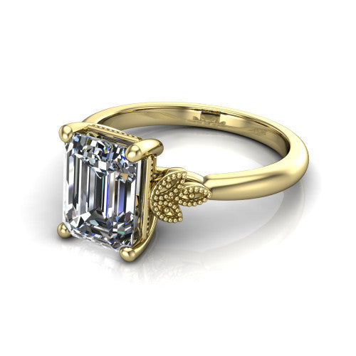 Athena emerald vintage solitaire engagement ring in 18K Yellow Gold, three-quarter perspective showing the emerald center on claw prongs above a plain band with fleur-de-lis filigree accents