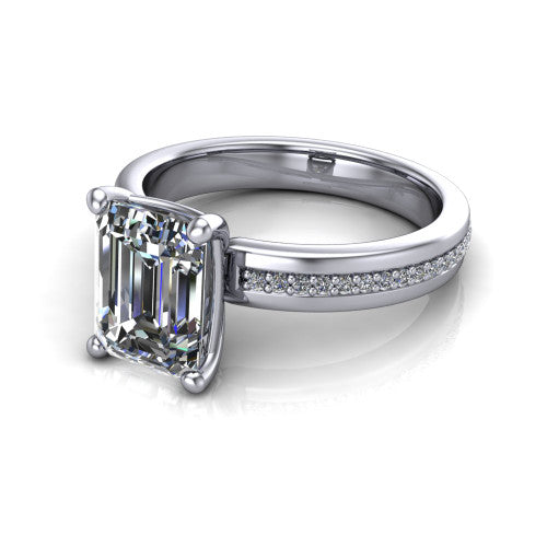 Kamala emerald classic solitaire engagement ring in Platinum, three-quarter perspective showing the emerald center on claw prongs above a wide channel-set pav&eacute; band