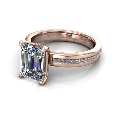 Kamala emerald classic solitaire engagement ring in 18K Rose Gold, three-quarter perspective showing the emerald center on claw prongs above a wide channel-set pav&eacute; band