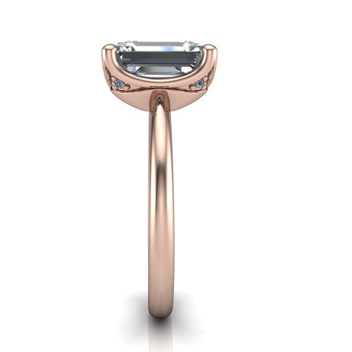 Josie emerald east-west solitaire engagement ring in 18K Rose Gold with plain band, side profile showing the plain band and bezel-set under-gallery accent
