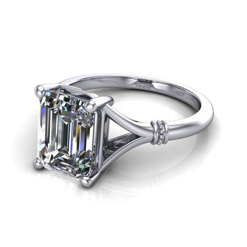 Luna emerald classic solitaire engagement ring in 18K White Gold, three-quarter perspective showing the emerald center on claw prongs above a plain split shank with pav&eacute; accent collars