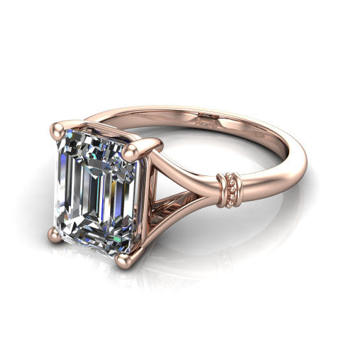 Luna emerald classic solitaire engagement ring in 14K Rose Gold, three-quarter perspective showing the emerald center on claw prongs above a plain split shank with pav&eacute; accent collars