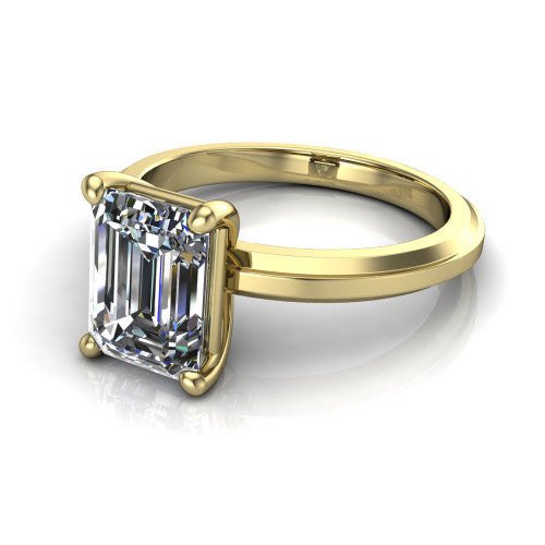 Ellie emerald classic solitaire engagement ring in 18K Yellow Gold, three-quarter perspective showing the emerald center on claw prongs above a wide flat knife-edge band