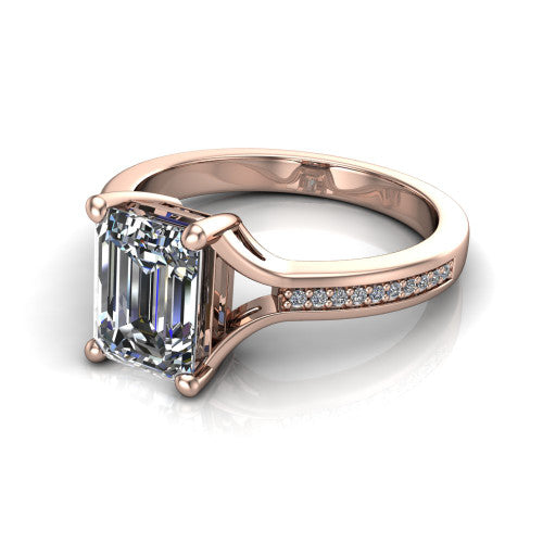 Isla emerald classic solitaire engagement ring in 18K Rose Gold, three-quarter perspective showing the emerald center on claw prongs above a channel-set pav&eacute; split shank