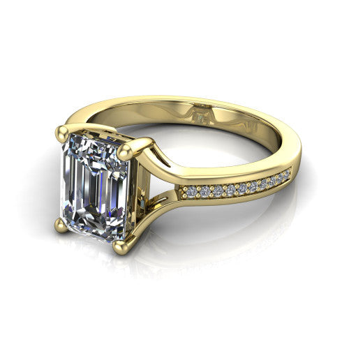Isla emerald classic solitaire engagement ring in 18K Yellow Gold, three-quarter perspective showing the emerald center on claw prongs above a channel-set pav&eacute; split shank