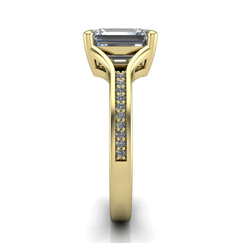 Isla emerald classic solitaire engagement ring in 14K Yellow Gold, side profile showing the channel-set pav&eacute; split shank with polished edges rising to the emerald center