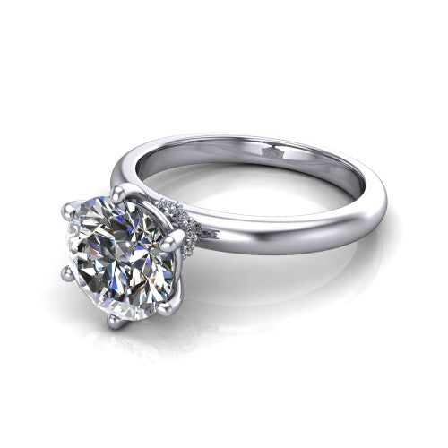 Delilah round hidden halo engagement ring in Platinum, three-quarter perspective showing the round center on claw prongs above a plain band with a hidden pav&eacute; halo