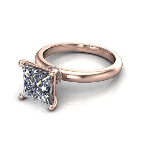 Delilah princess hidden halo engagement ring in 14K Rose Gold, three-quarter perspective showing the princess center on claw prongs above a plain band with a hidden pav&eacute; halo