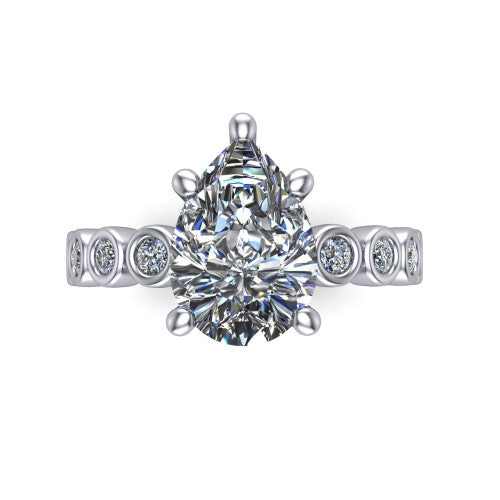Kinsley pear solitaire engagement ring in Platinum with bezel-set diamond accent band, top-down view of the center stone and bezel band
