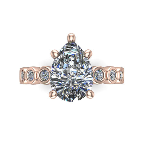 Kinsley pear solitaire engagement ring in 18K Rose Gold with bezel-set diamond accent band, top-down view of the center stone and bezel band