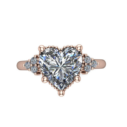 Brianna heart three stone engagement ring in 18K Rose Gold with milgrain-framed center and round side clusters, top-down view of the milgrain-framed center and side accent clusters