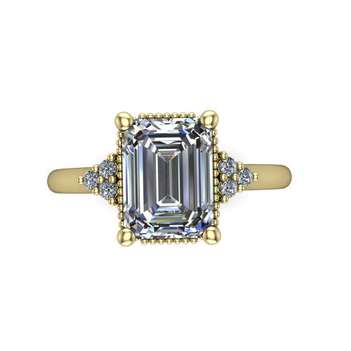 Brianna emerald three stone engagement ring in 14K Yellow Gold with milgrain-framed center and round side clusters, top-down view of the milgrain-framed center and side accent clusters