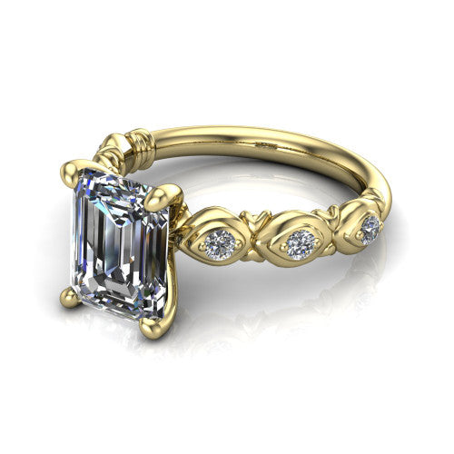 Nyla emerald-cut solitaire engagement ring in 18K Yellow Gold, three-quarter perspective showing the emerald-cut center diamond above a vintage marquise-station accent band