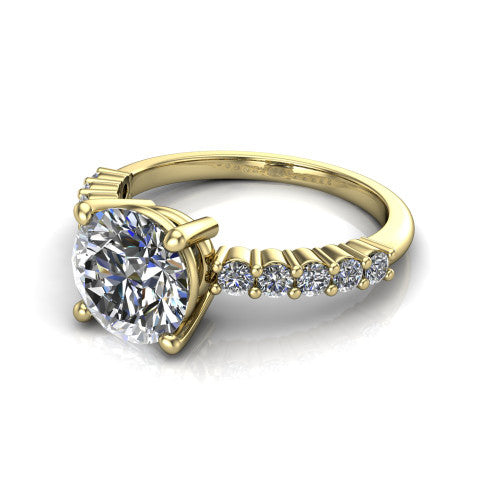 Fernanda round solitaire engagement ring in 18K Yellow Gold, three-quarter perspective showing the round center diamond, 4-prong setting, and shared-prong pave band