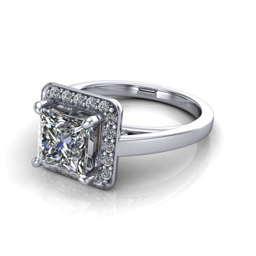 Coralie princess-cut halo engagement ring in 18K White Gold, three-quarter perspective showing the princess-cut center diamond, milgrain pavé halo, and polished band