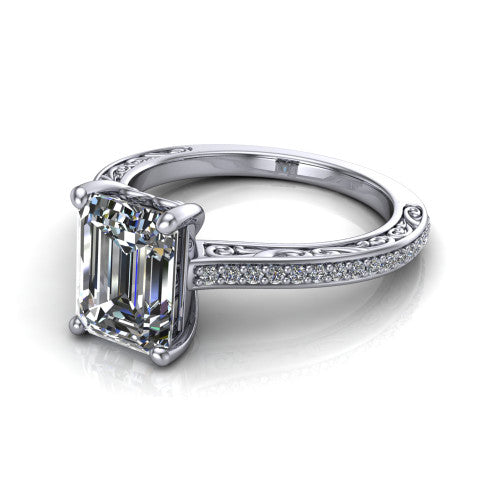 Nicole emerald solitaire engagement ring in Platinum, three-quarter perspective showing the emerald center diamond above a pave band with scrollwork engraving
