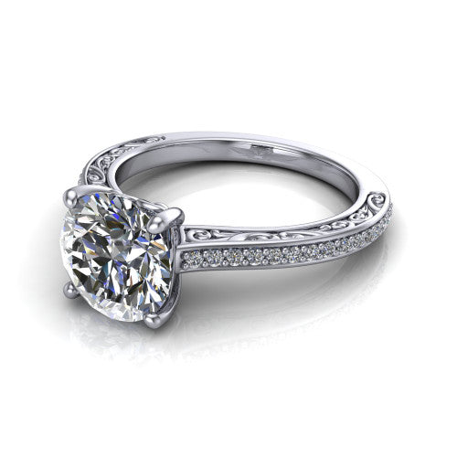 Nicole round solitaire engagement ring in 18K White Gold, three-quarter perspective showing the round center diamond above a pave band with scrollwork engraving