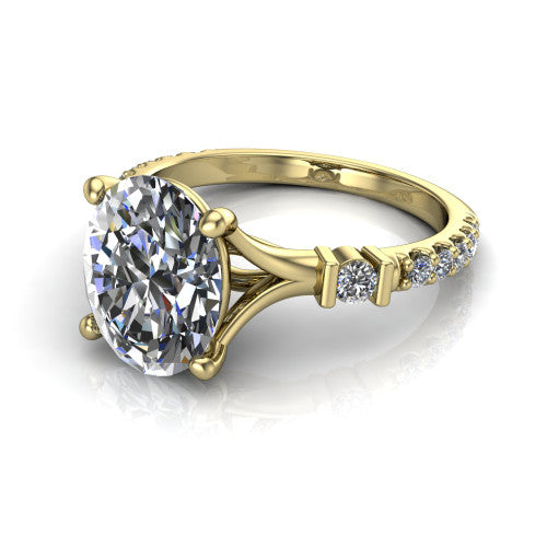 Arabella oval solitaire engagement ring in 18K Yellow Gold, three-quarter perspective showing the oval center diamond above a pave band with bezel-set shoulder accents