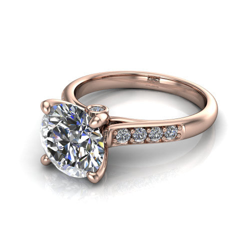 Nena round solitaire engagement ring in 18K Rose Gold, three-quarter perspective showing the round center diamond above channel-set shoulders