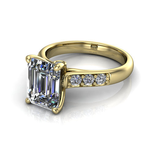 Nena emerald solitaire engagement ring in 14K Yellow Gold, three-quarter perspective showing the emerald center diamond above channel-set shoulders