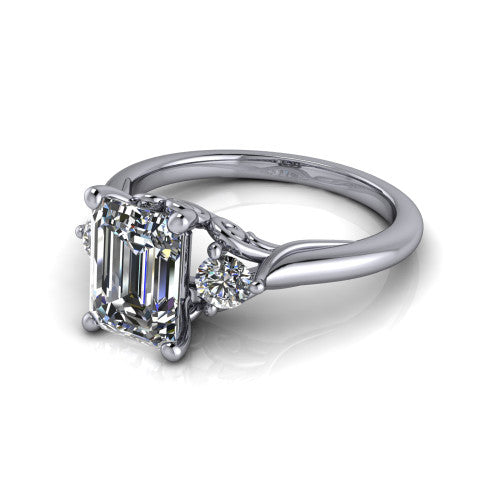 Harley emerald three stone engagement ring in 18K White Gold, three-quarter perspective showing the step-cut emerald center diamond flanked by two round side diamonds on tapered cathedral shoulders