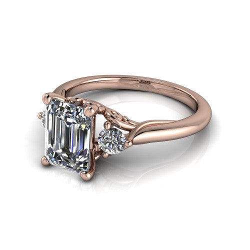 Harley emerald three stone engagement ring in 14K Rose Gold, three-quarter perspective showing the step-cut emerald center diamond flanked by two round side diamonds on tapered cathedral shoulders