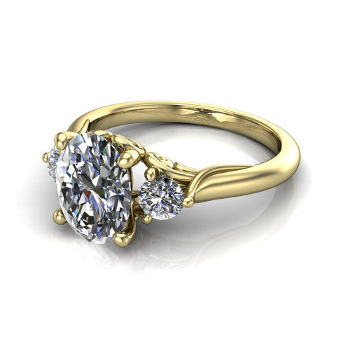 Harley oval three stone engagement ring in 18K Yellow Gold, three-quarter perspective showing the brilliant oval center diamond flanked by two round side diamonds on tapered cathedral shoulders