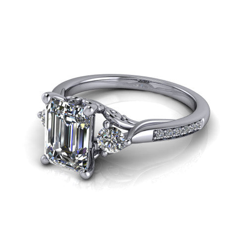 Celine emerald three stone engagement ring in 18K White Gold, three-quarter perspective showing the step-cut emerald center diamond flanked by two round side diamonds on a pave band