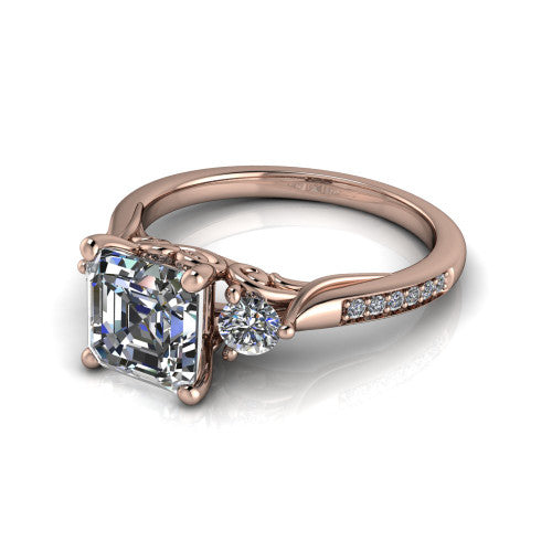 Celine square emerald three stone engagement ring in 18K Rose Gold, three-quarter perspective showing the step-cut square emerald center diamond flanked by two round side diamonds on a pave band