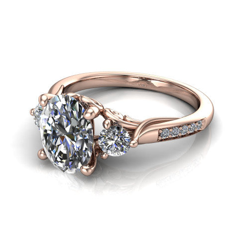 Celine oval three stone engagement ring in 18K Rose Gold, three-quarter perspective showing the brilliant oval center diamond flanked by two round side diamonds on a pave band