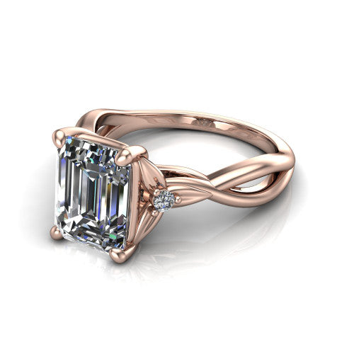 Catalina emerald three stone engagement ring in 18K Rose Gold, three-quarter perspective showing the step-cut emerald center diamond flanked by two round side accent diamonds on a twisted infinity shank