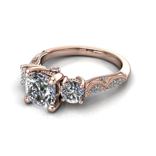 Rosemary cushion three stone engagement ring in 14K Rose Gold, three-quarter perspective showing the three-stone row with milgrain shoulders and filigree detailing above a pav&eacute; band
