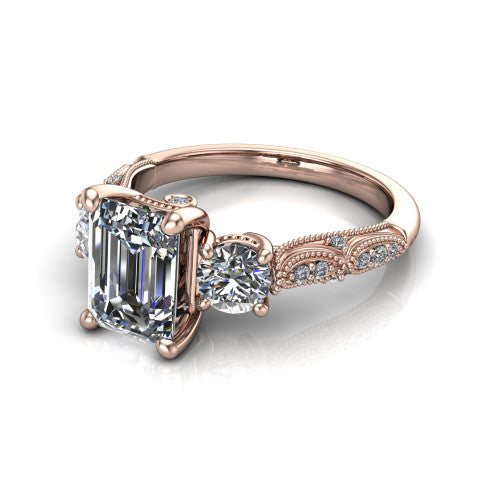 Rosemary emerald three stone engagement ring in 14K Rose Gold, three-quarter perspective showing the three-stone row with milgrain shoulders and filigree detailing above a pav&eacute; band