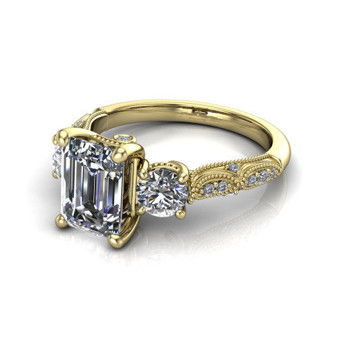 Rosemary emerald three stone engagement ring in 14K Yellow Gold, three-quarter perspective showing the three-stone row with milgrain shoulders and filigree detailing above a pav&eacute; band