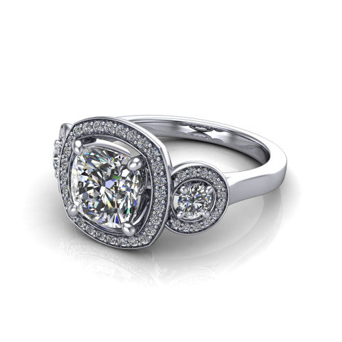 Colette cushion three-stone halo engagement ring in Platinum, three-quarter perspective showing the cushion center diamond and two round side stones, each in a pave halo, across the band