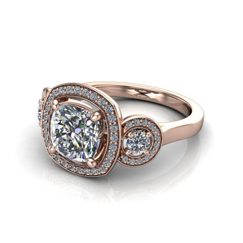 Colette cushion three-stone halo engagement ring in 14K Rose Gold, three-quarter perspective showing the cushion center diamond and two round side stones, each in a pave halo, across the band