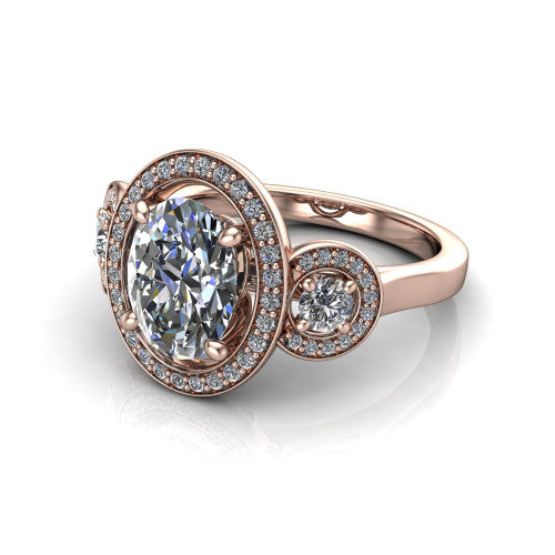 Colette oval three-stone halo engagement ring in 14K Rose Gold, three-quarter perspective showing the oval center diamond and two round side stones, each in a pave halo, across the band