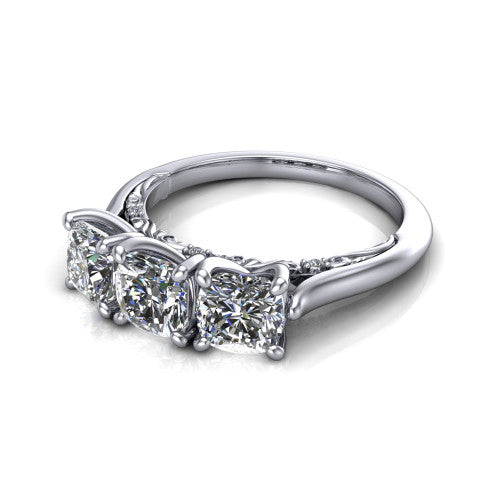 Kora cushion three-stone engagement ring in 18K White Gold, three-quarter perspective showing the three matched cushion diamonds, pave-set band, and vintage scrollwork gallery