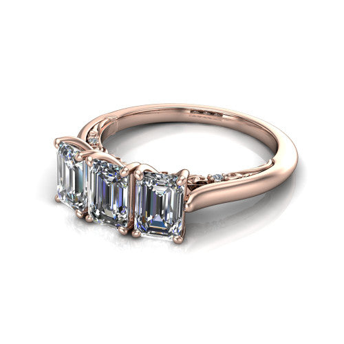 Kora emerald-cut three-stone engagement ring in 14K Rose Gold, three-quarter perspective showing the three matched emerald-cut diamonds, pave-set band, and vintage scrollwork gallery