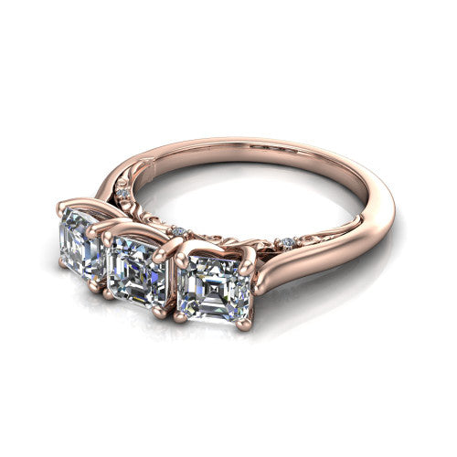 Kora square emerald-cut three-stone engagement ring in 14K Rose Gold, three-quarter perspective showing the three matched square emerald-cut diamonds, pave-set band, and vintage scrollwork gallery