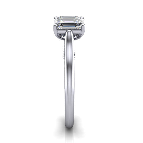 Kora emerald-cut three-stone engagement ring in Platinum, side profile showing the pave-set band, scrollwork gallery, and high-polish profile