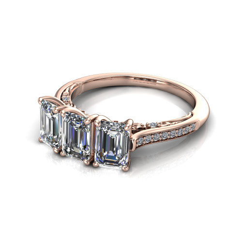 Emory emerald-cut three-stone engagement ring in 14K Rose Gold, three-quarter perspective showing the three matched emerald-cut diamonds, pave-set band, and filigree under-gallery