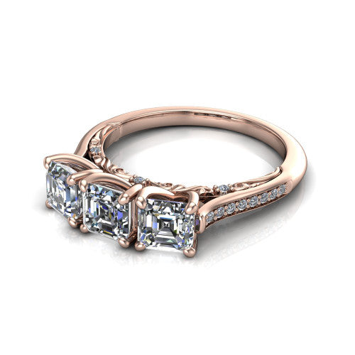 Emory square emerald-cut three-stone engagement ring in 14K Rose Gold, three-quarter perspective showing the three matched square emerald-cut diamonds, pave-set band, and filigree under-gallery